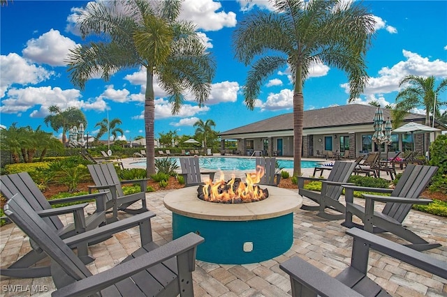 view of patio with an outdoor fire pit and a community pool