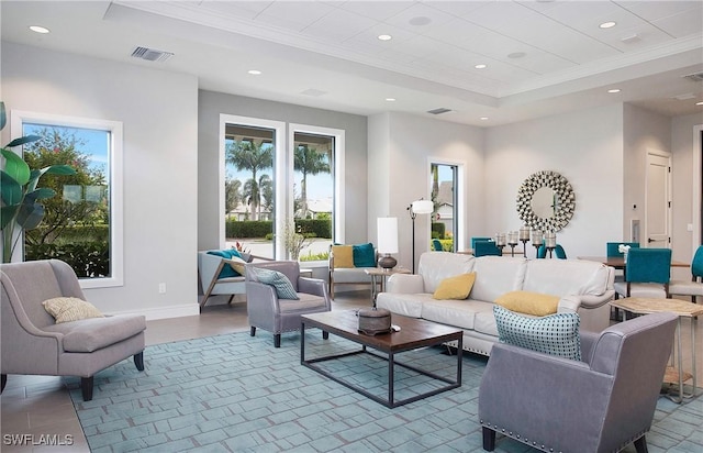 living room with visible vents, crown molding, baseboards, a tray ceiling, and recessed lighting