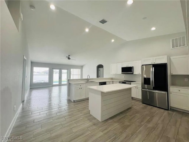 kitchen featuring kitchen peninsula, stainless steel appliances, white cabinetry, and ceiling fan