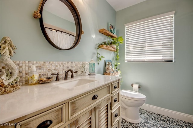 bathroom featuring tile patterned flooring, vanity, toilet, and backsplash