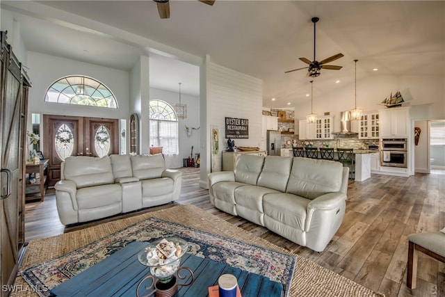 living room with ceiling fan, high vaulted ceiling, and dark hardwood / wood-style floors