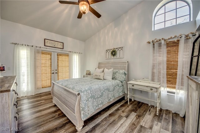 bedroom featuring french doors, a towering ceiling, dark hardwood / wood-style floors, and ceiling fan