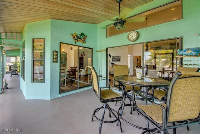 dining space with ceiling fan, wooden ceiling, and concrete floors