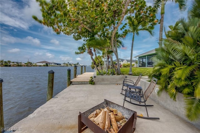 view of patio / terrace featuring a dock, a water view, and a fire pit