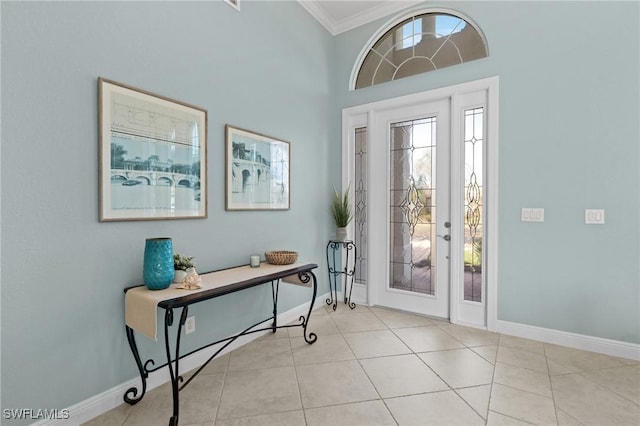 entrance foyer with light tile patterned floors, crown molding, and a towering ceiling