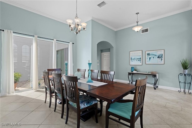 tiled dining space with a towering ceiling, ornamental molding, and a chandelier