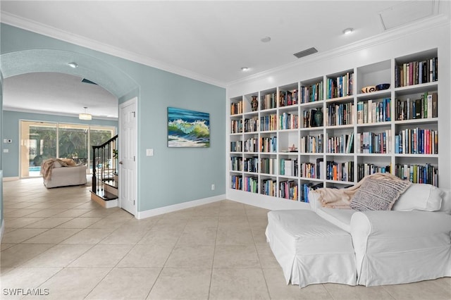 living area with ornamental molding, light tile patterned floors, and built in shelves