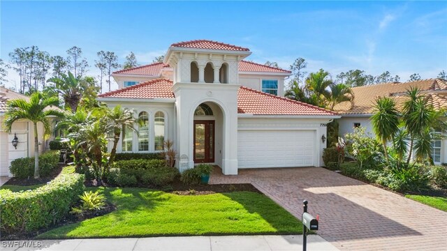 mediterranean / spanish-style home featuring a front yard and a garage