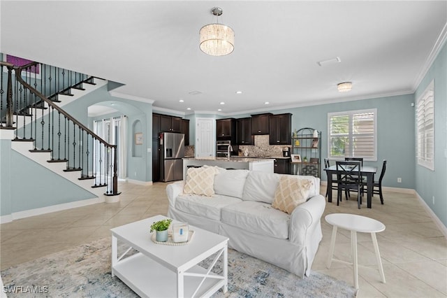 living room with crown molding, sink, and light tile patterned floors