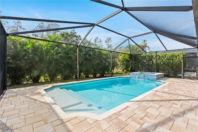 view of pool featuring an in ground hot tub, a patio area, and glass enclosure