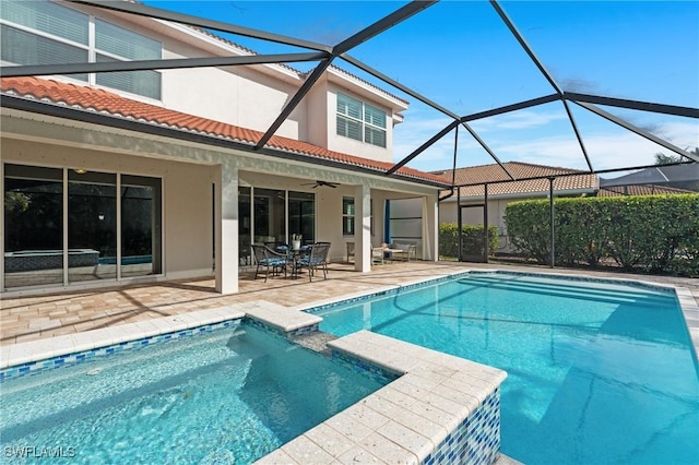 view of swimming pool featuring a patio area, ceiling fan, and glass enclosure