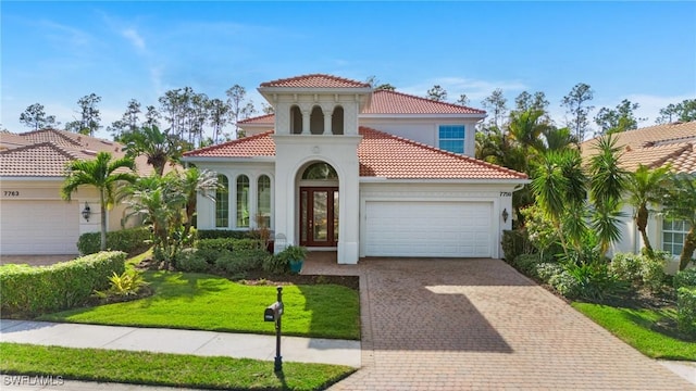 mediterranean / spanish home featuring a garage and a front yard