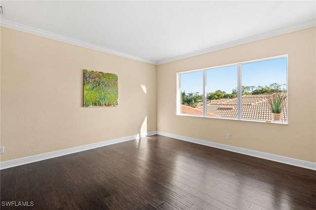 empty room featuring dark wood-type flooring and ornamental molding