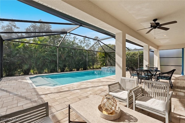 view of swimming pool with a patio area, an in ground hot tub, ceiling fan, and glass enclosure