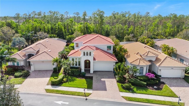 7759 Martino Cir, Naples, FL 34112 - view of front of property featuring a tile roof, decorative driveway, stucco siding, and a garage
