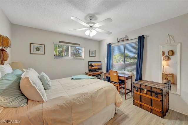 bedroom with ceiling fan, a textured ceiling, and light wood-type flooring