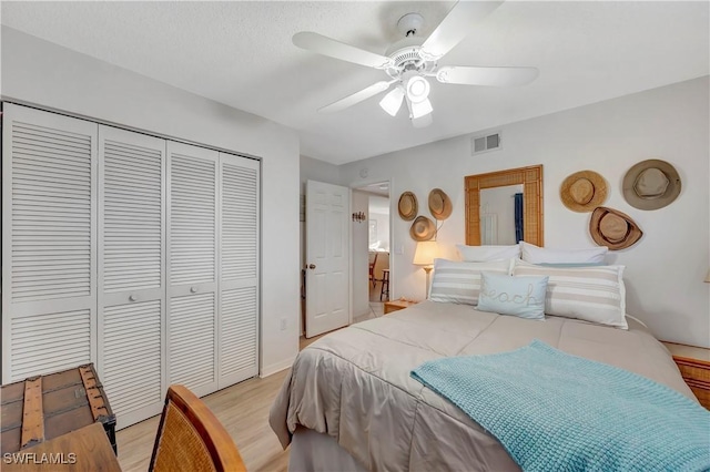 bedroom featuring light hardwood / wood-style floors, a closet, and ceiling fan