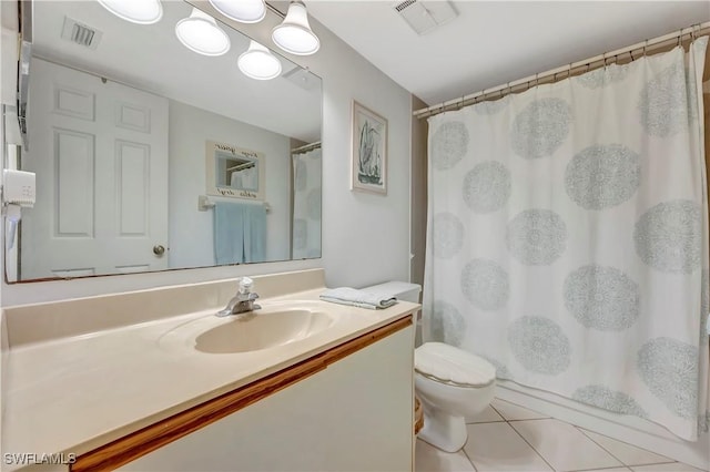 bathroom featuring tile patterned flooring, vanity, toilet, and walk in shower