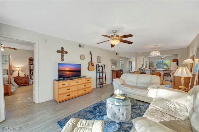 living room with ceiling fan and light wood-type flooring