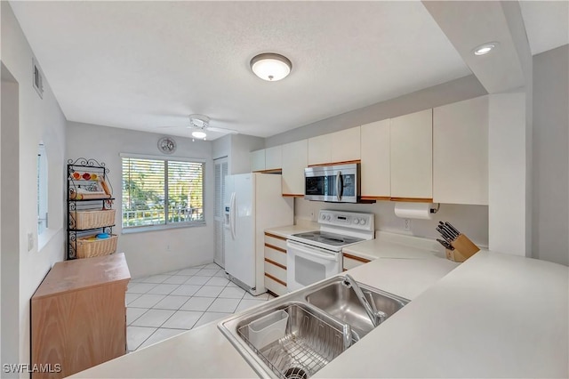 kitchen featuring white appliances, white cabinets, sink, ceiling fan, and light tile patterned floors