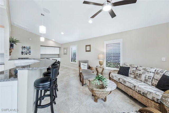 living room featuring ceiling fan and vaulted ceiling