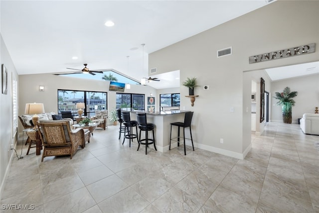 kitchen with a breakfast bar, ceiling fan, and lofted ceiling