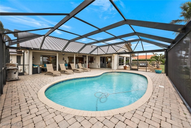 view of swimming pool featuring glass enclosure and a patio area