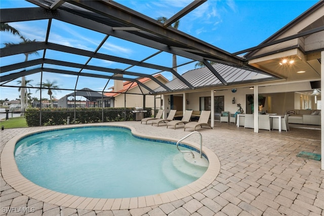 view of pool featuring an outdoor living space, glass enclosure, and a patio area