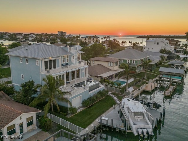 aerial view at dusk featuring a water view