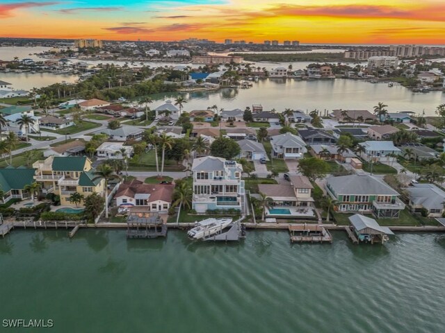 aerial view at dusk featuring a water view