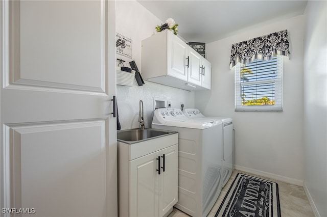 washroom with sink, cabinets, and independent washer and dryer