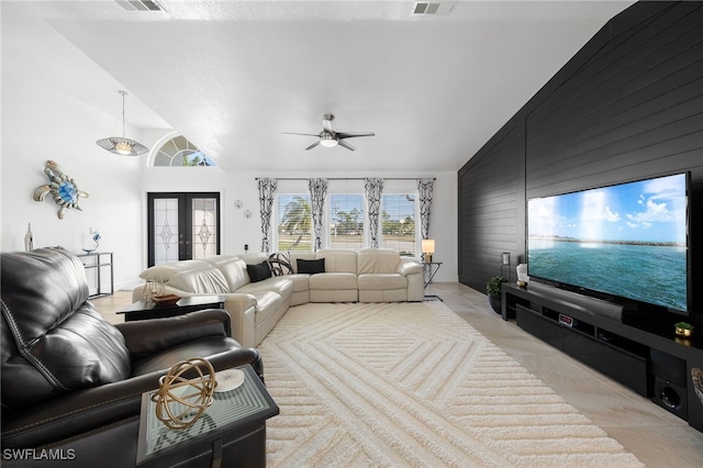 living room featuring french doors, light tile patterned flooring, wood walls, high vaulted ceiling, and ceiling fan