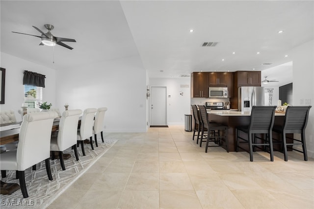 dining space featuring ceiling fan and light tile patterned floors