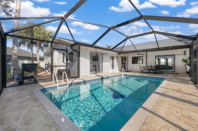 view of swimming pool with ceiling fan, a lanai, and a patio area