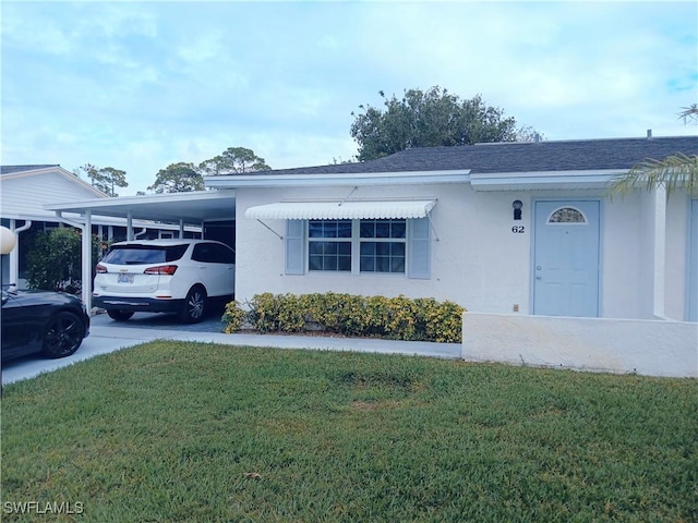 single story home with a front yard and a carport