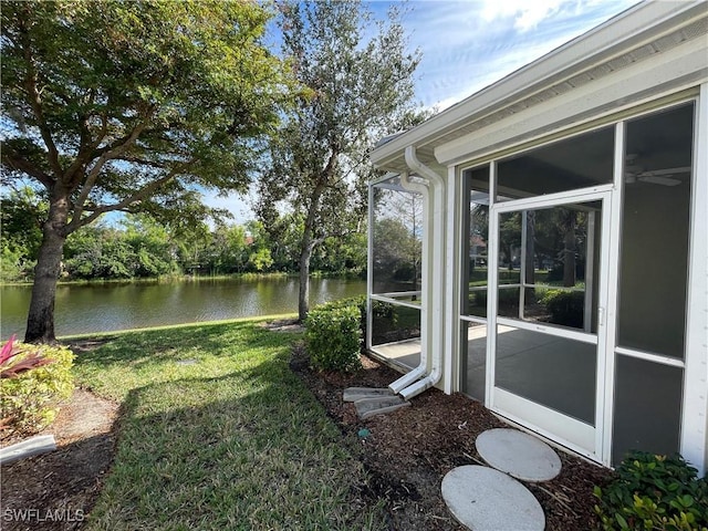 view of yard featuring a water view and a sunroom