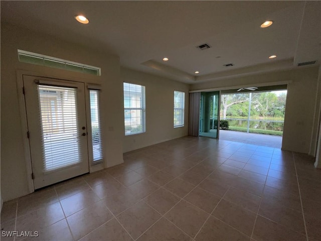 tiled spare room featuring a raised ceiling