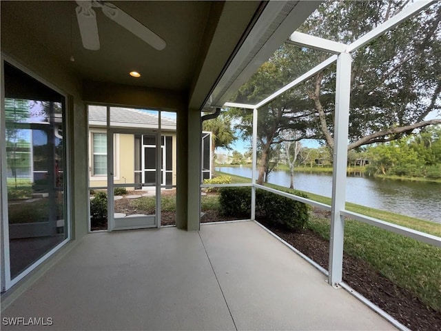 unfurnished sunroom with ceiling fan and a water view