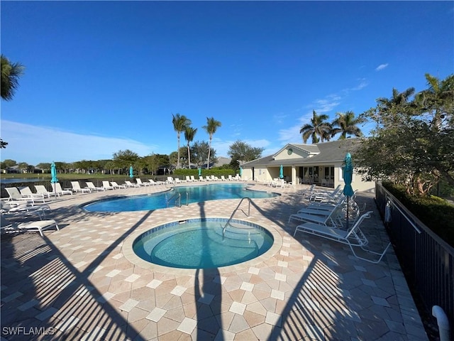 view of swimming pool featuring a hot tub and a patio area