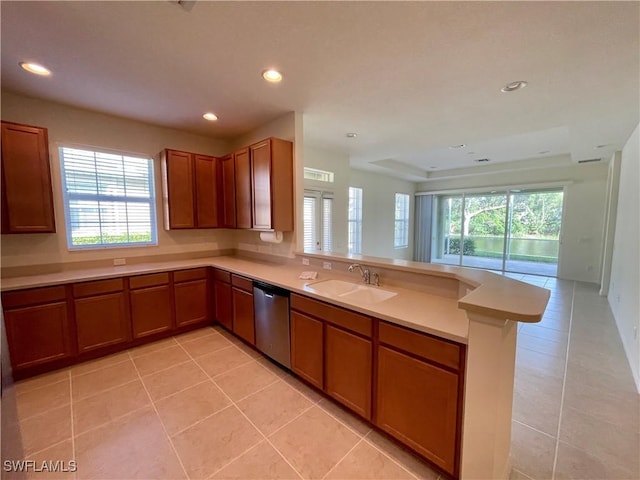 kitchen with kitchen peninsula, sink, light tile patterned floors, and stainless steel dishwasher