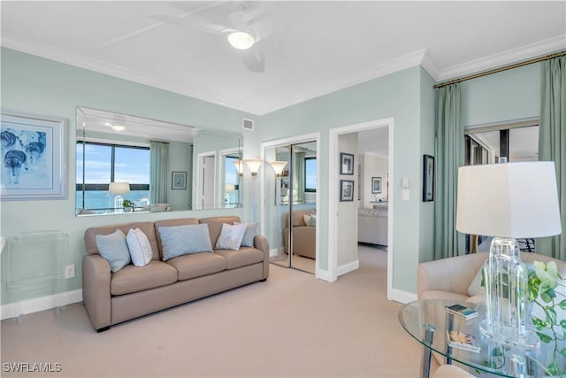 carpeted living room with ornamental molding, ceiling fan, and a water view