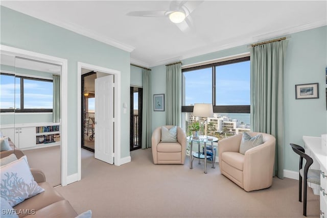 living room featuring ceiling fan, light colored carpet, ornamental molding, and a water view