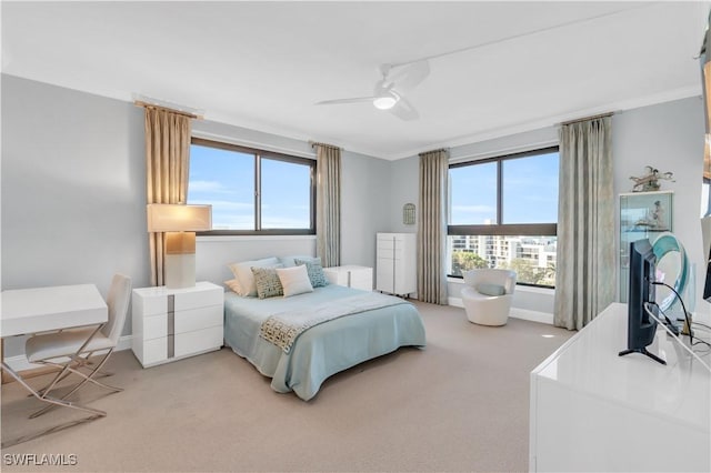 bedroom featuring multiple windows, crown molding, carpet, and ceiling fan