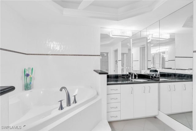 bathroom featuring vanity, a tub, and a tray ceiling