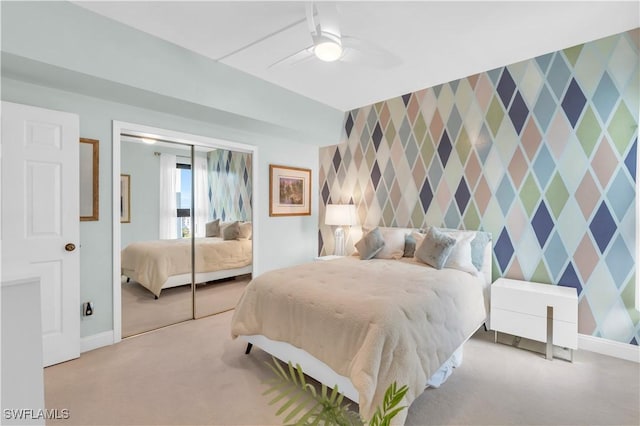 carpeted bedroom with ceiling fan and a closet