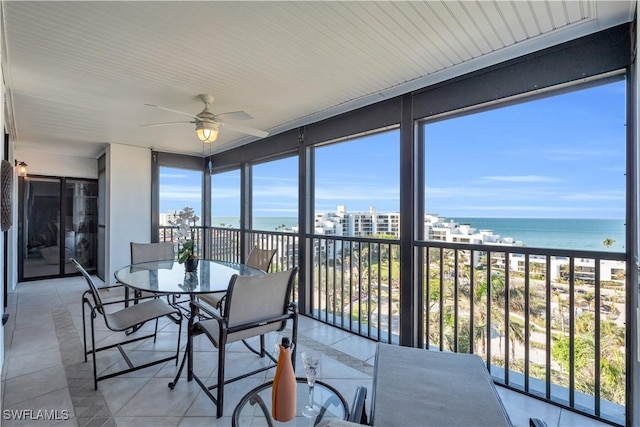 sunroom featuring a water view, plenty of natural light, a beach view, and ceiling fan