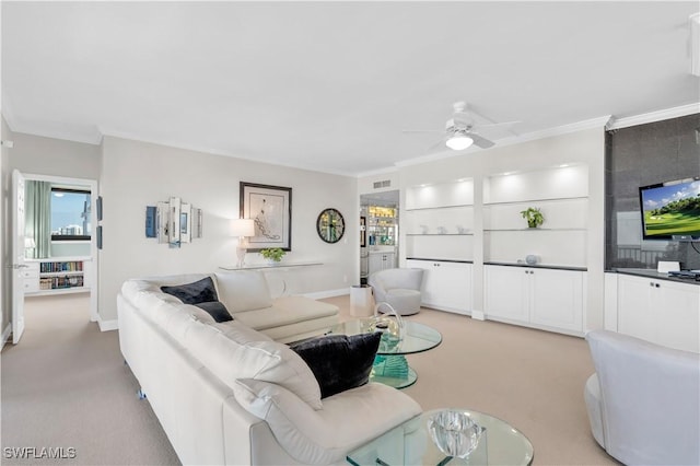 carpeted living room featuring crown molding and ceiling fan