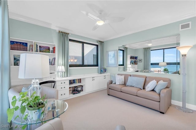 carpeted living room with a water view, ornamental molding, and plenty of natural light