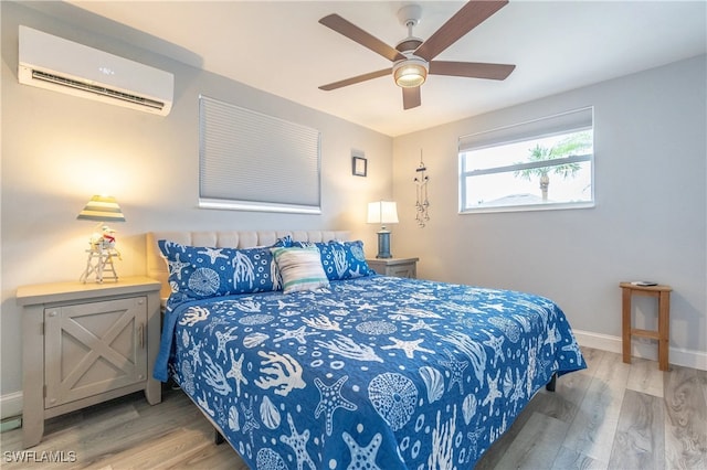 bedroom with ceiling fan, wood-type flooring, and an AC wall unit