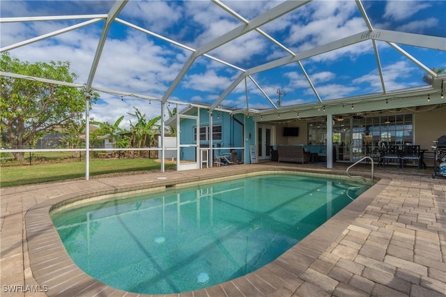 view of swimming pool with outdoor lounge area, a lanai, a patio area, and ceiling fan